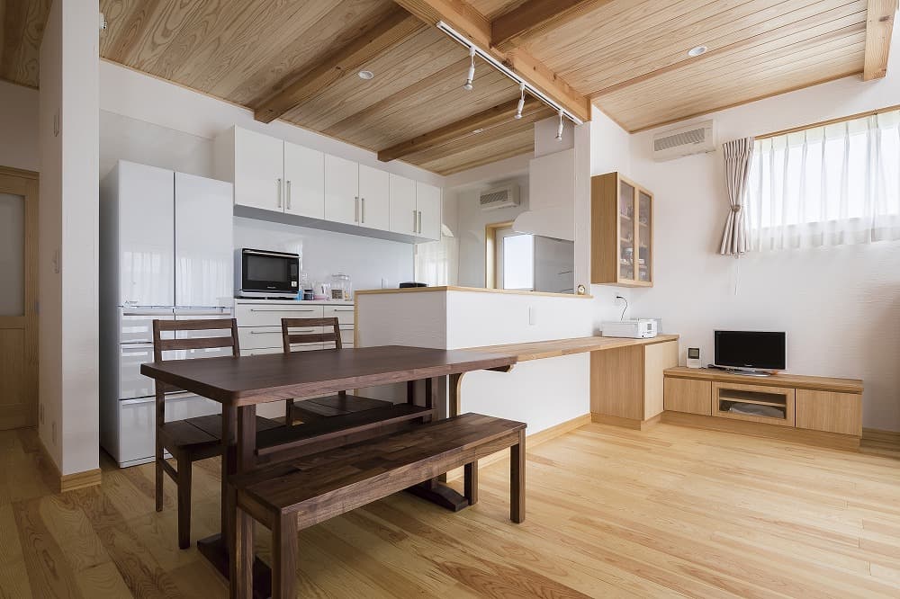 ダークブラウンのダイニングセットが映える、白と木のコントラスト住宅