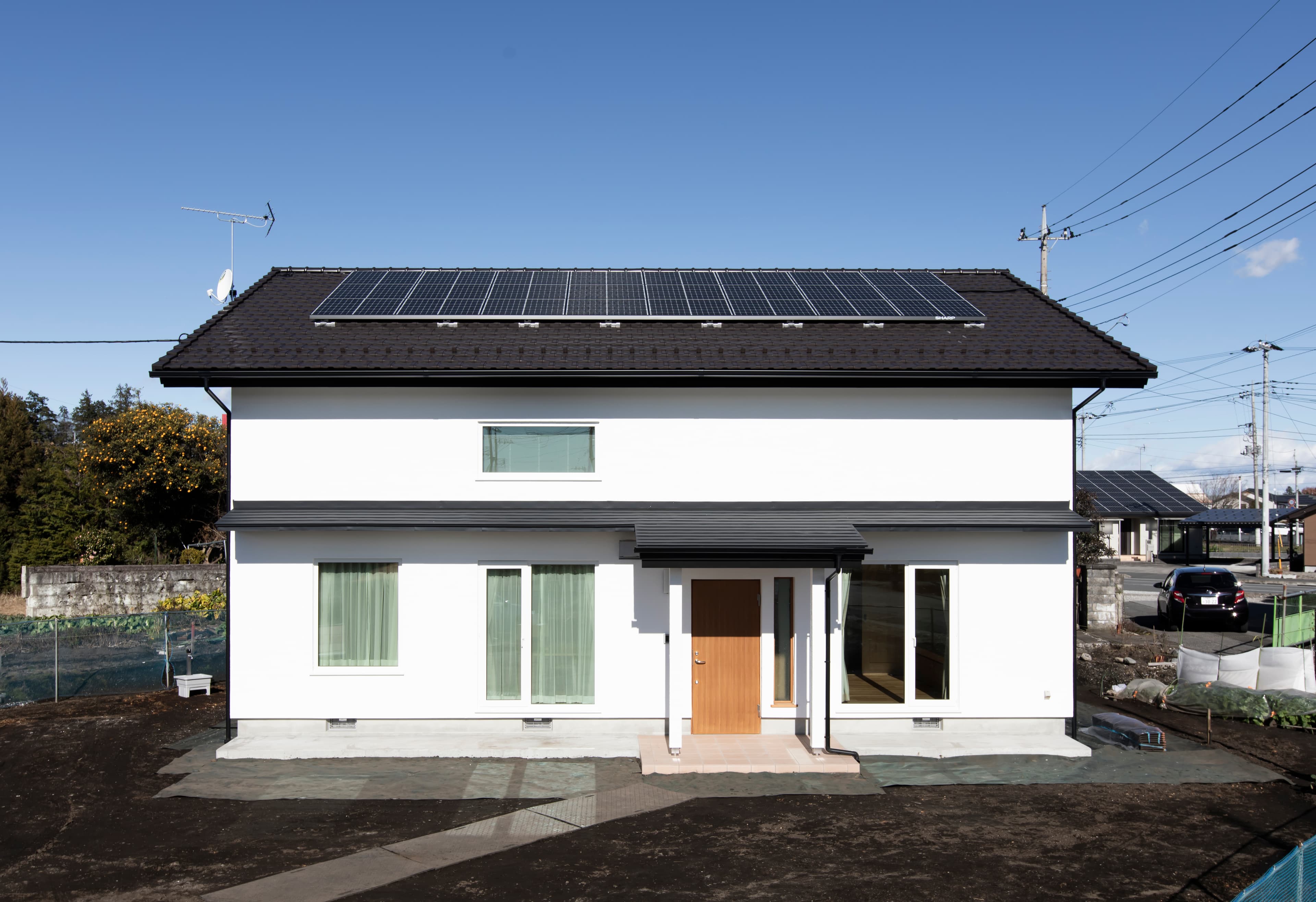 天窓から光が降り注ぐ、木製階段が空間をつなぐ吹き抜けの住まい