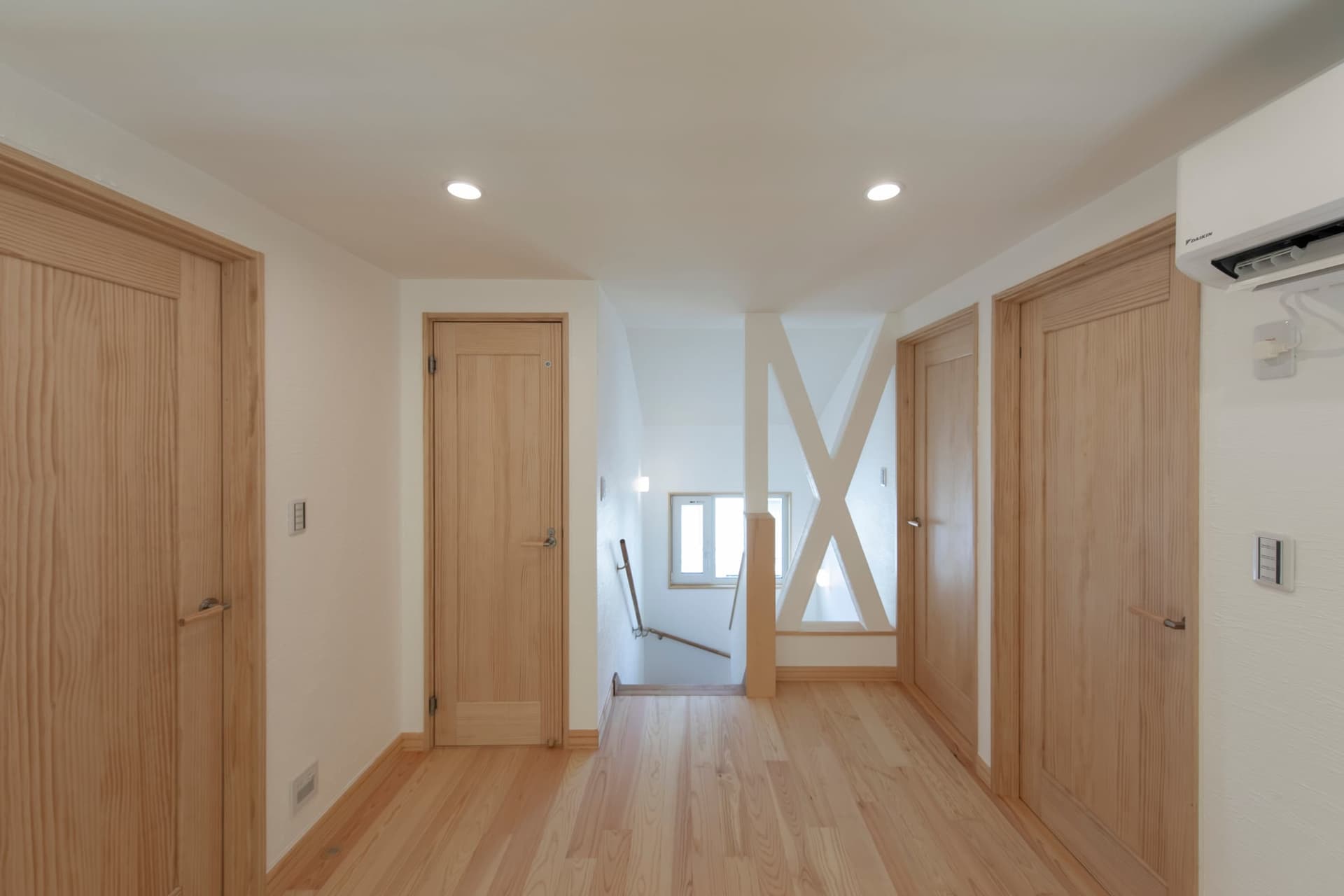 木製の腰壁とデスクが一体となった明るいワークスペースのある家